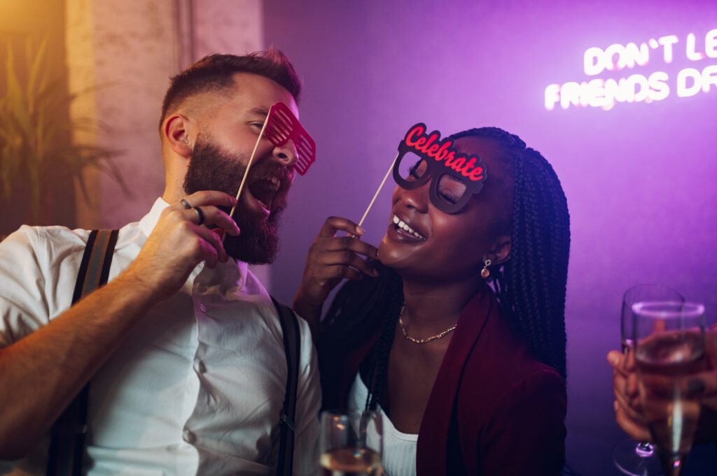 Happy couple dancing on a party in a club while drinking champag